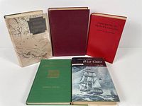 Five hardcover books on a flat surface including titles on Western Canada and British Columbia history