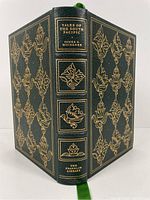 Front and back cover of the book with detailed gilt embossing and green leather binding with ribbon marker visible.