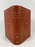 Spine and front/back cover showing rich brown leather binding with gold foil accents and decoration