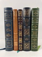 Spine view showing five leather-bound books with gilt decoration and silk bookmarks.