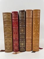 Five leather-bound Franklin Library books showing gilt titles and decoration on spines and front covers in various colors.