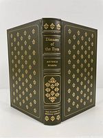 Full front and back cover of leather bound book with gilt decorative patterns and lettering on spine.
