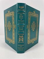 Front and back cover of the green leather bound book showing gilt decorative borders and text on spine.