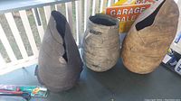 Three large pottery jugs on a table, showing size and damage