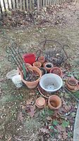 Overview of all items laid out on ground showing various pots, planters, and metal stands