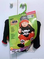 Photo of baby girl pirate costume in original packaging showing set components and product branding.