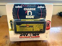 Front view of Schumacher Charge n Ride universal charger in opened packaging, showing product label and branding