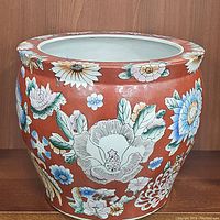 Full view of vintage pottery flower planter with rust red color and detailed multicolor floral design.