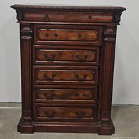 Front view showing six drawers with detailed carved trim and decorative handles.