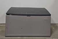 Front view of the grey Suncast deck box with closed black lid