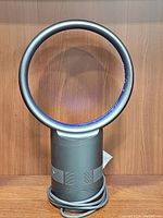 Front view of Dyson bladeless fan showing circular air multiplier ring and black base with power cord.