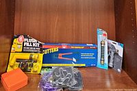 Overview of flush fill kit, red handled bolt cutters, steel links, drilling kit components and plastic part box.