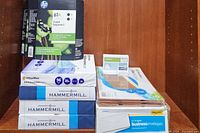 Photo showing 2-pack of HP 61XL Tri-color Ink Cartridges stacked on 4 reams of Hammermill copy paper and 2 packages of business envelopes and 5 pack file pockets.