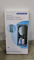 Photo of the product box showing The Container Store branding and image of the double hang clothes closet in charcoal color with hanging clothes inside.