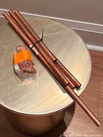 Several copper pipes tied together laid on a round drum-like surface with plastic bag containing copper fittings