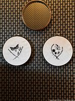 Both embroidery hoops displayed on patterned wall with mirror above