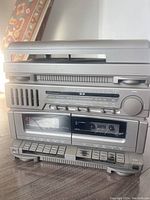 Front view of the vintage stereo system showing the top-loading turntable, AM/FM tuner, equalizer sliders, and two cassette decks.
