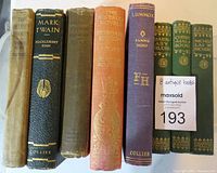 Front view of the 8 antique books showing spines and titles
