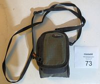 Closed Lowepro branded camera carrying case with shoulder strap on white background