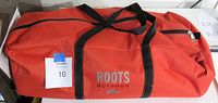 Orange ROOTS Outdoor branded carry bag for the tent, showing brand name and carrying handles.
