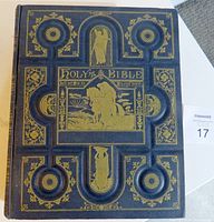 Front cover of the Bible showing elaborate gold embossing on dark leather with biblical imagery and text 'Holy Bible'.