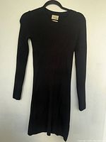 Front view of the black long sleeve sweater dress showing ribbed texture and round neckline.