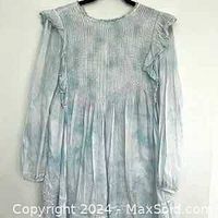 Front view of a light baby blue and white bohemian style dress with long sleeves and smocked bodice
