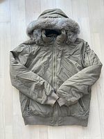 Front view of moss green women's Bench jacket showing zip-up front, fur-trimmed hood, ribbed cuffs and waistband.