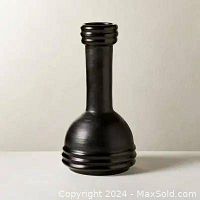 Front angled view of a black ceramic vase showing smooth rounded base and narrow neck with ring details