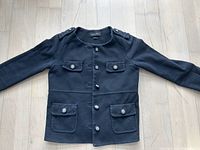 Front view of black Massimo Dutti jacket laid flat showing decorative buttons and pockets.