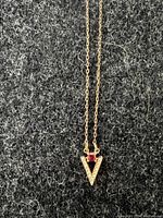 Close-up of the 'V' pendant with white crystals and pink crystal on delicate rose gold tone chain.