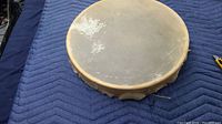 Top view of the drum showing natural animal hide head with some discoloration.