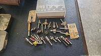 Router bits arranged on a table, some in original packaging.