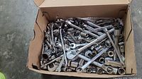Full view of box filled with assorted wrenches, sockets, ratchets and extensions showing a variety of metal hand tools.