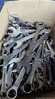 Photo showing a box filled with various imperial size wrenches, some with sizes visible like 3/4 inch.