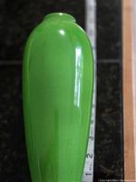 Full side view of the green ceramic vase showing its shape and glossy finish.