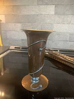 Front view of Flemish style mixed metal vase with spiral metal accent, flared top, and circular base.