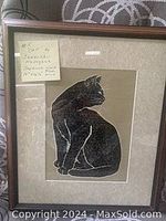 Frontal view of the framed wood block print featuring a black cat with a mat and wooden frame.