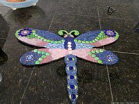 Full top view of the large colorful mosaic dragonfly wall hanging showing its vibrant wings and body.