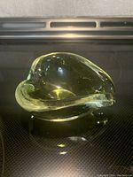 Top and side view of the greenish Murano glass dish showing its organic freeform shape and thickness of glass.