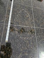 Full length of the chain on granite surface with measuring tape indicating approximately 18 inches.