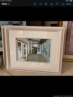 Framed picture showing white porch with columns and shadow of a person.