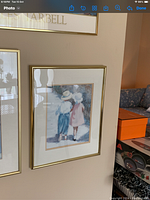 Framed picture of boy and girl holding hands in vintage style with gold frame.