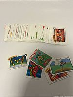 Stack of vintage Disney trading cards fanned out showing various colorful illustrations and titles.