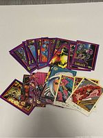 Assortment of Marvel comic cards fanned out showing colorful character artwork and purple borders.