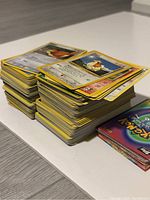 Stack of Pokémon cards with yellow borders and various characters.