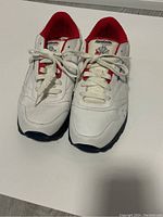 Front view of white and red Reebok Classic sneakers showing upper details and laces