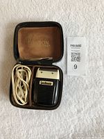 Open leather case containing Ronson electric shaver and cord laid out inside.