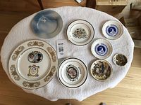 Top view of 8 assorted decorative bone china plates varying in size and design.
