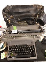 Front view of the vintage Underwood typewriter with keys, paper roller, and mechanical parts visible. Shows the typewriter with black keys and brand name.